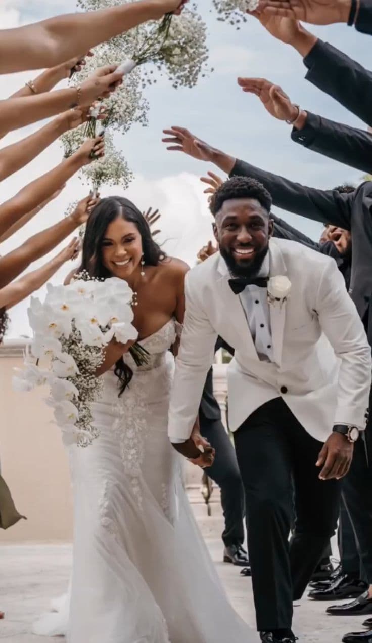 A couple walking out through cheering guests